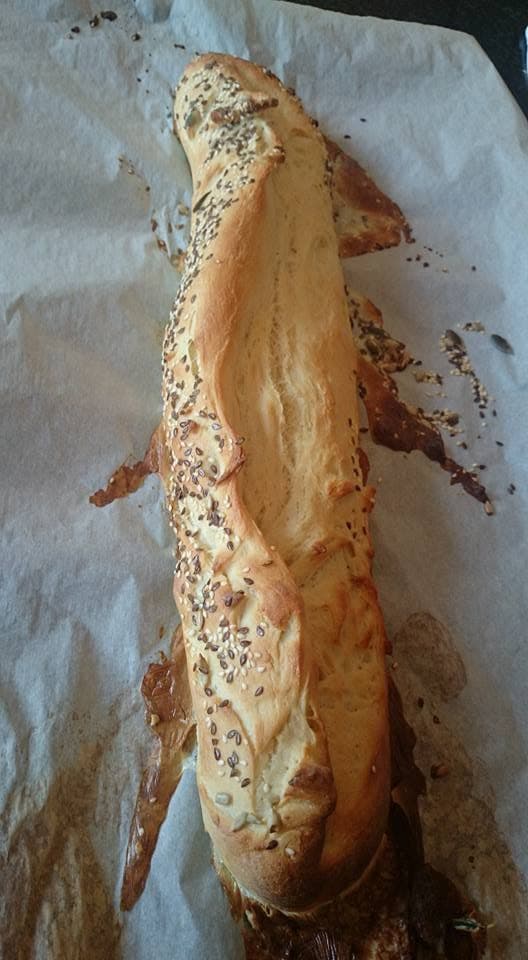 A seeded loaf, baked at home, on brown paper