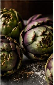 Fresh artichokes on dark slate