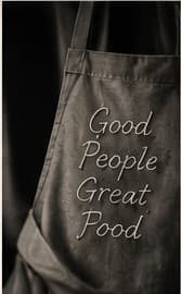 A charcoal apron embroidered with the words Good People Great Food