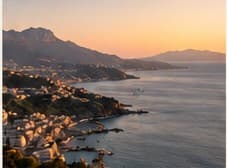 A coastal town and mountains at sunset