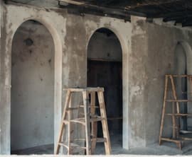 Plastered arches with a ladder, the finishes going in