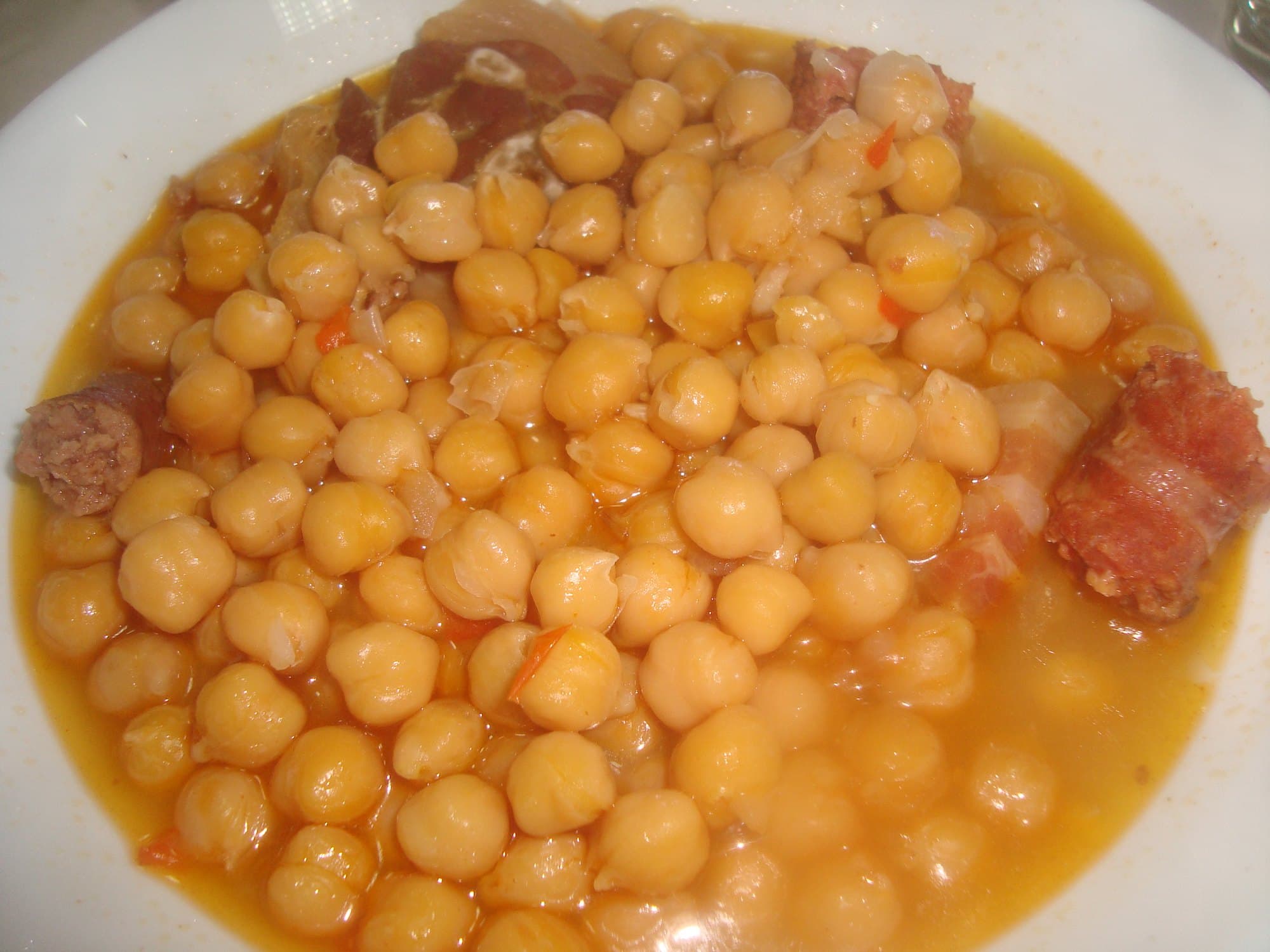 Cooked chickpeas in their golden cooking liquid