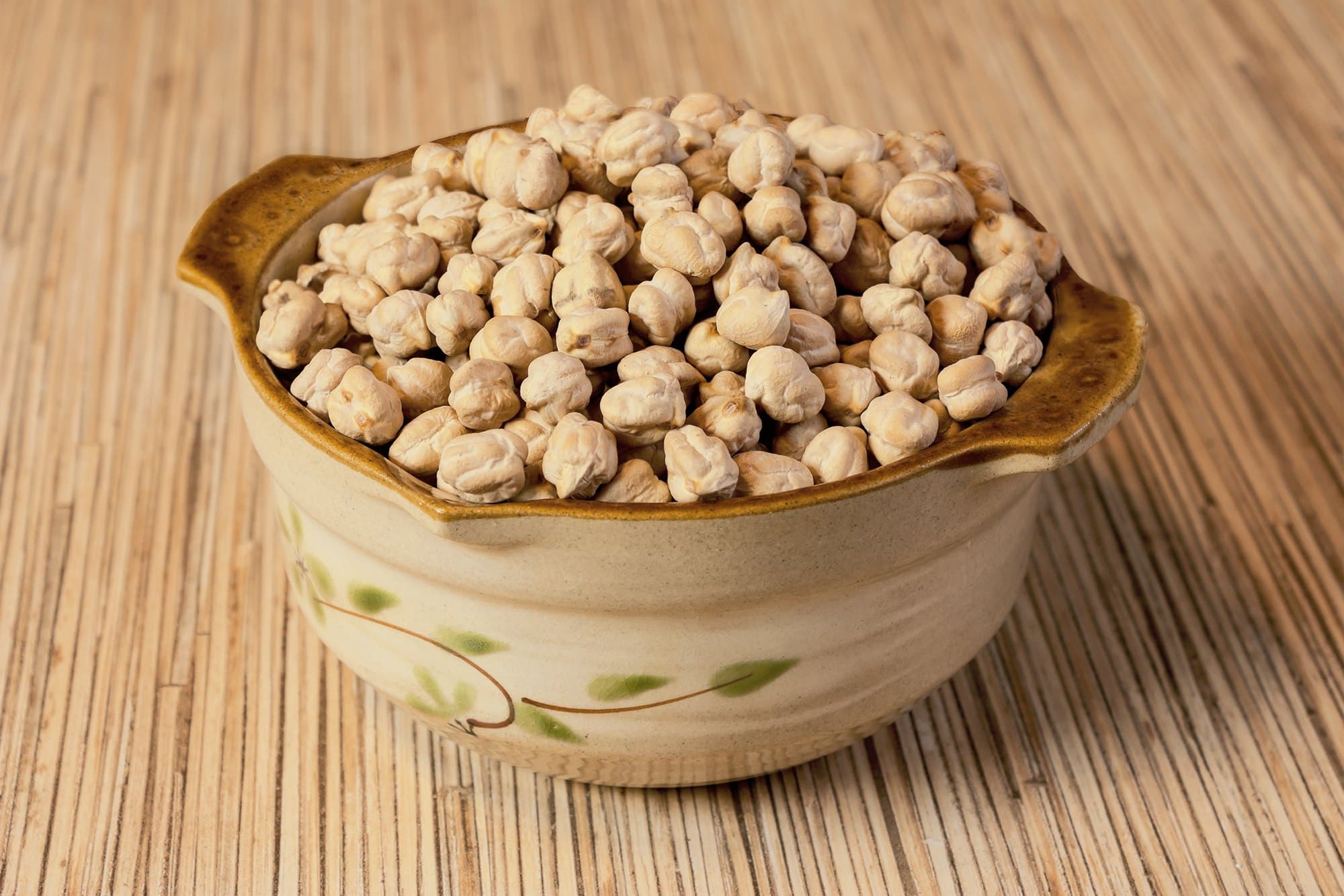 Dried cream-coloured chickpeas heaped in a ceramic bowl