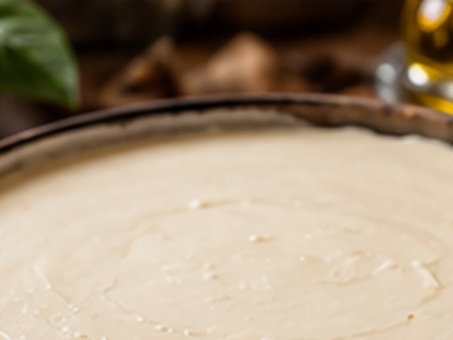 Smooth pale cultured cheesecake base before baking, mixed to a low-aeration finish.