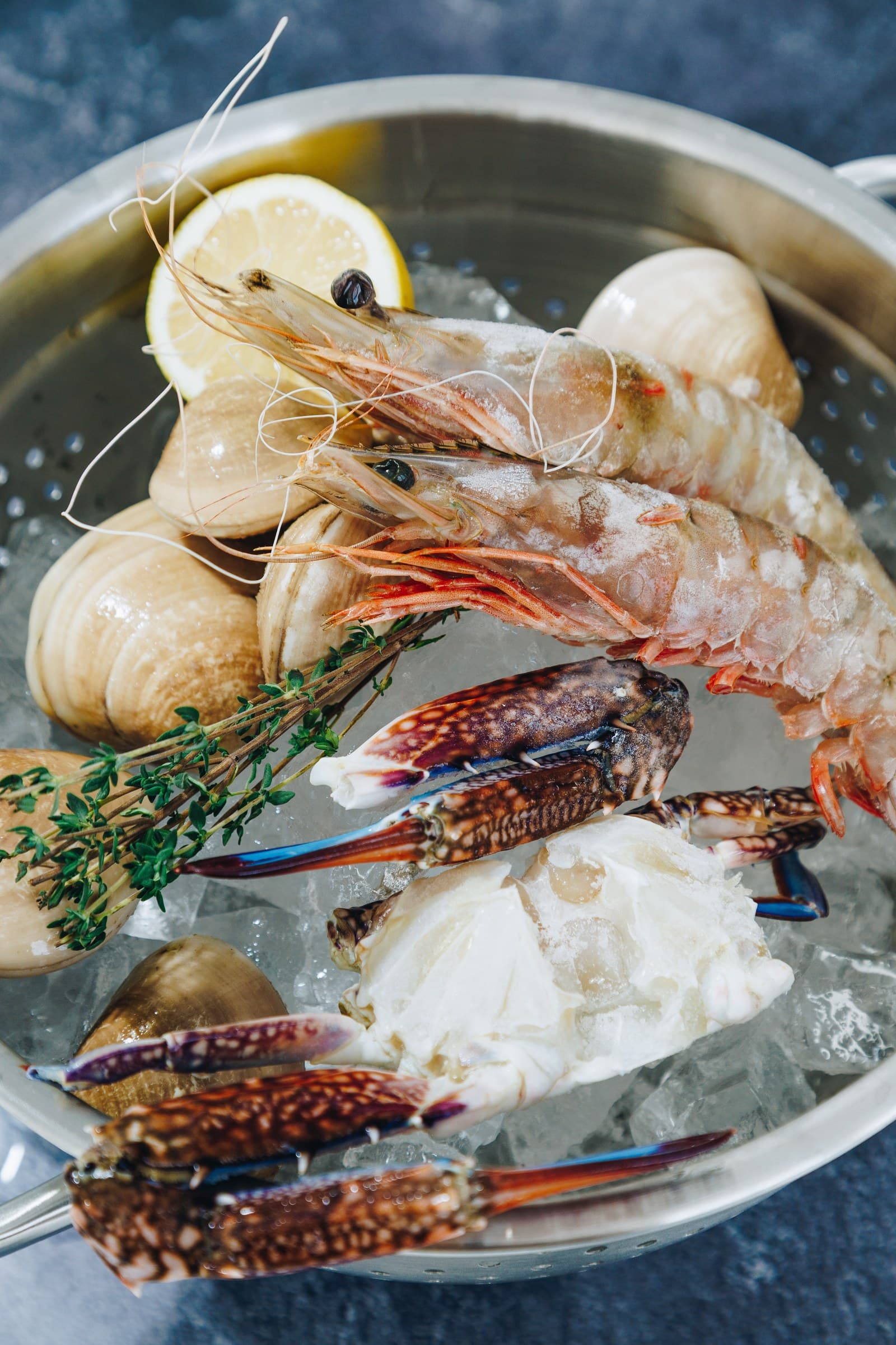 Clams, whole prawns, a blue crab and thyme on crushed ice