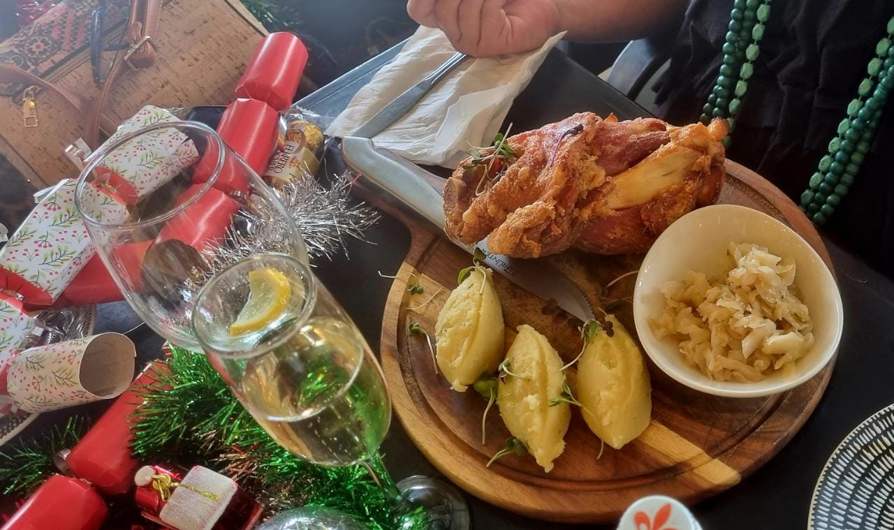 A festive restaurant table with roast chicken and accompaniments